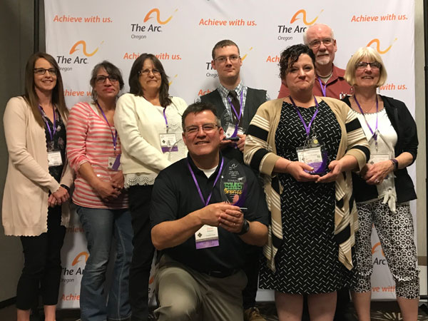 2019 award winners with awards in front of The Arc backdrop