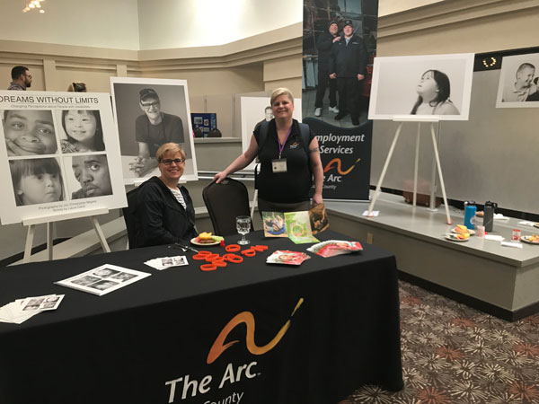 The Arc Lane County exhibit table with Angela and Laura
