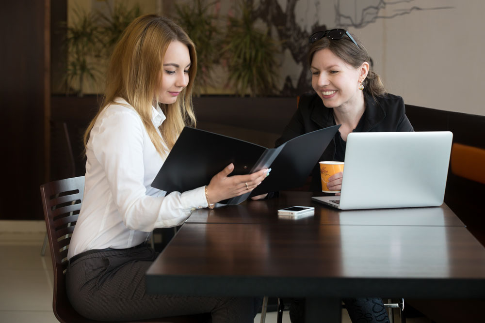 two women professionals having a work meeting at a table