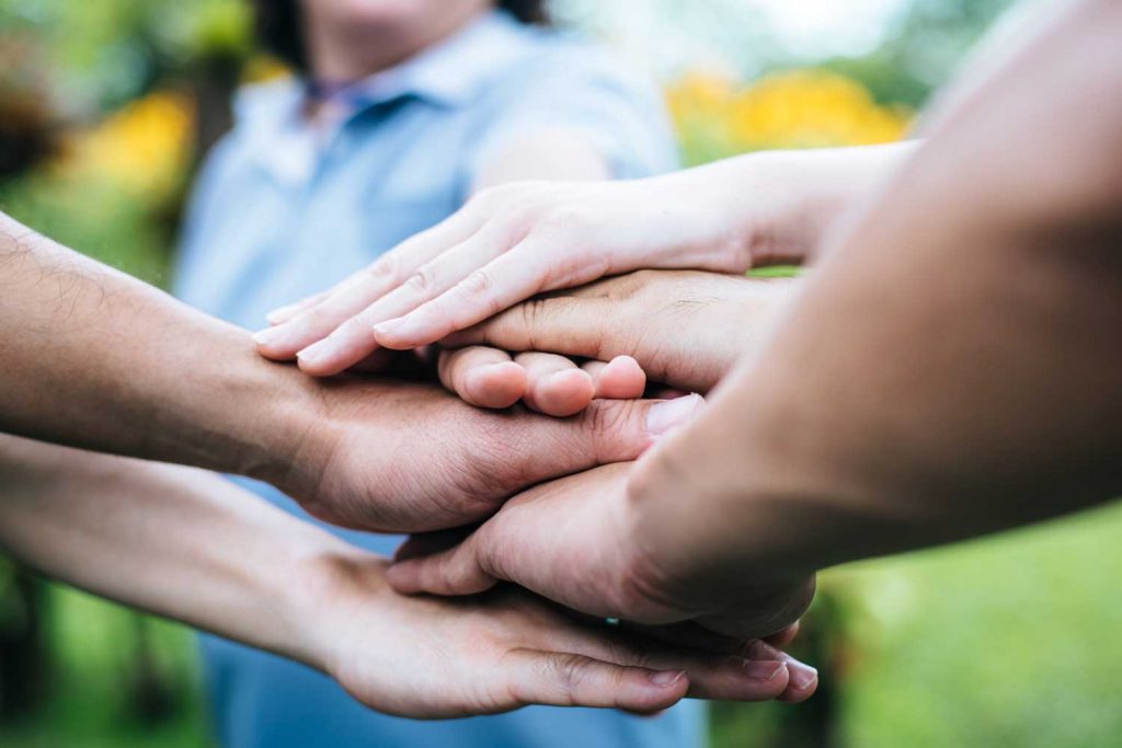 Image of many hands stacked on top of each other.