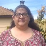 Photo of DiAnna Hicks-Ross standing outside in front of a house