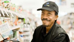 man in baseball cap stocking shelves at a store