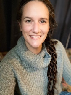 Jennie Heidrick con cabello trenzado en un suéter gris.