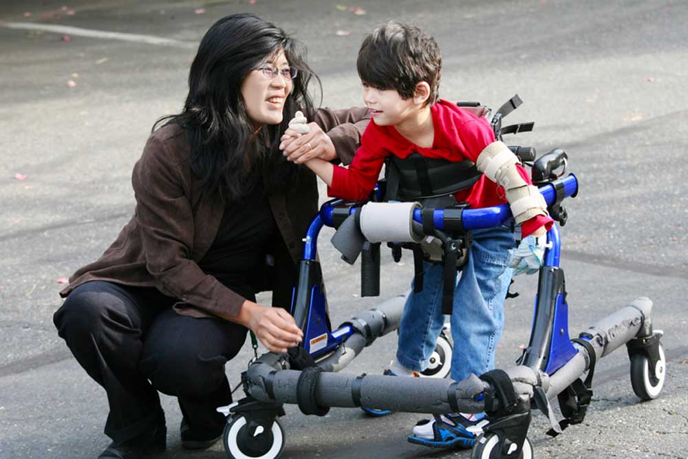 A mom with her son. The son is in a walker.