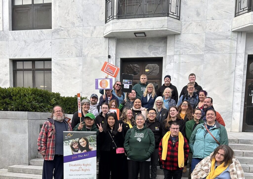 A large group of advocates gathered outside the Oregon State Capitol, holding a sign that reads Disability Rights are Human Rights.